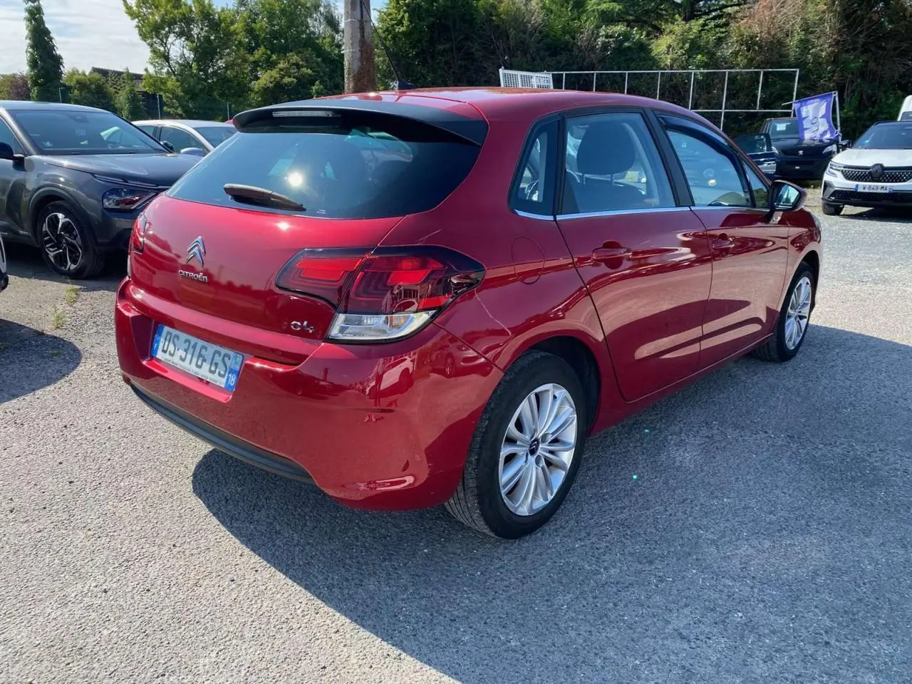 Citroën C4 rouge métallisé vue 3/4 arrière droit avec feux arrière distinctifs et jantes alliage.