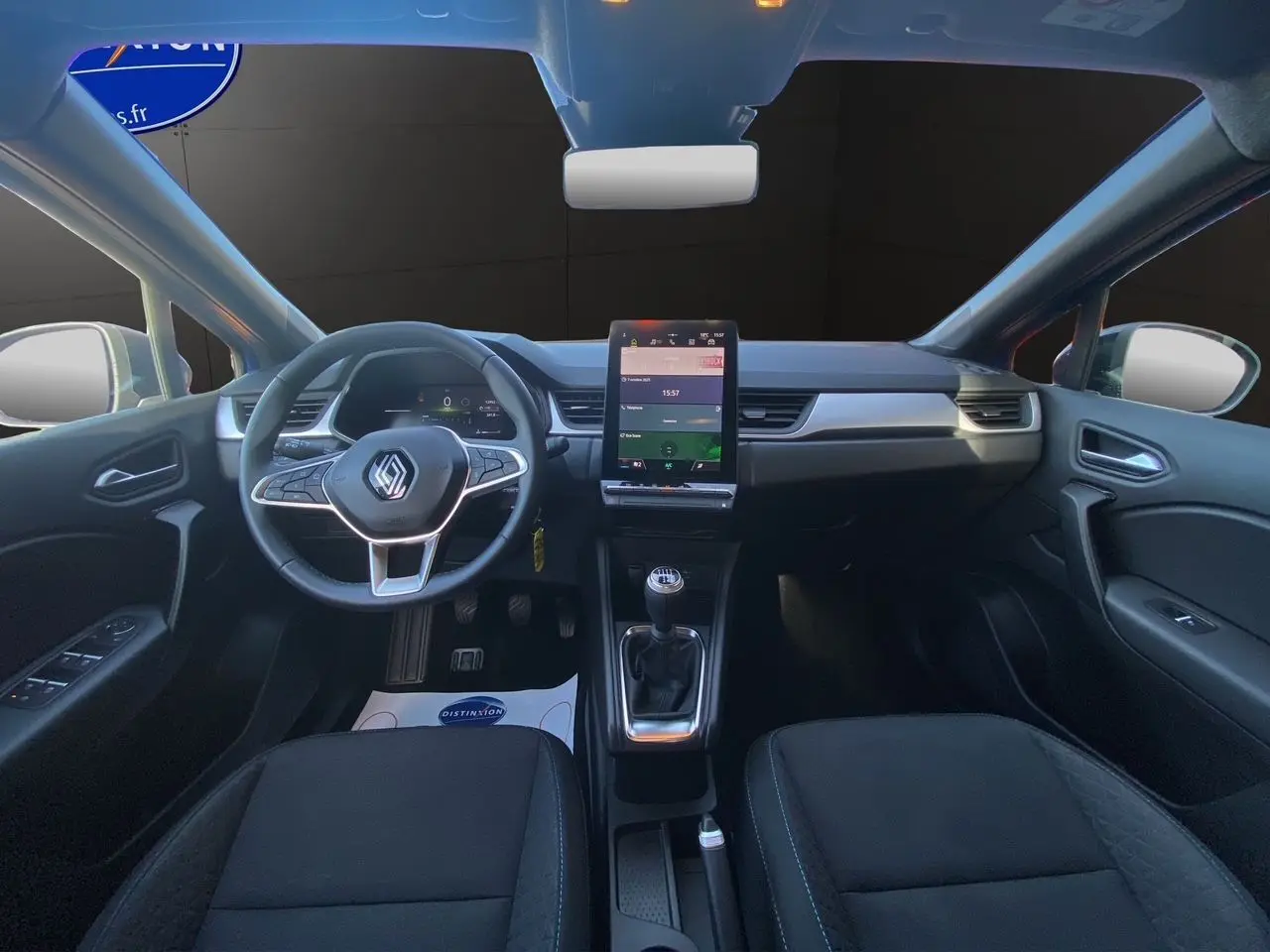 Intérieur du Renault Captur TCE 90 Evolution 2024, vue frontale du tableau de bord avec écran tactile vertical et levier de vitesses manuel.