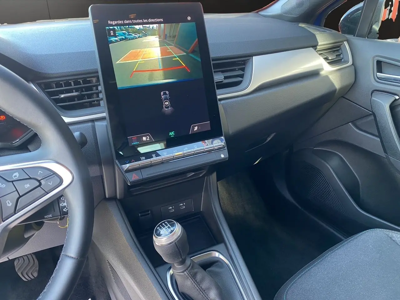 Intérieur du Renault Captur 2024 TCE 90 Evolution, vue sur la console centrale avec écran tactile et levier de vitesses manuel.