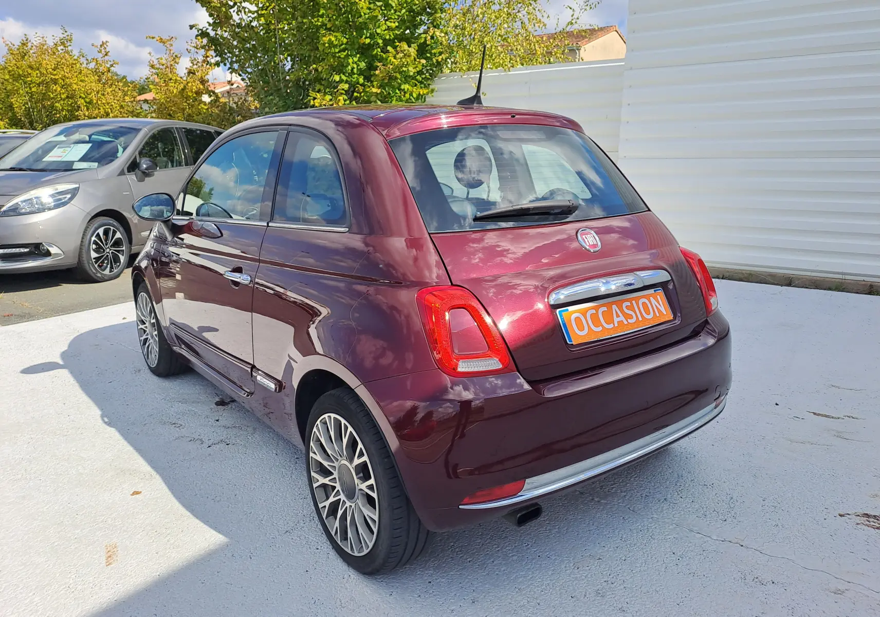 Fiat 500 Opera Bordeaux métal vue 3/4 arrière droit, avec jantes alliage et plaque "OCCASION" visible.