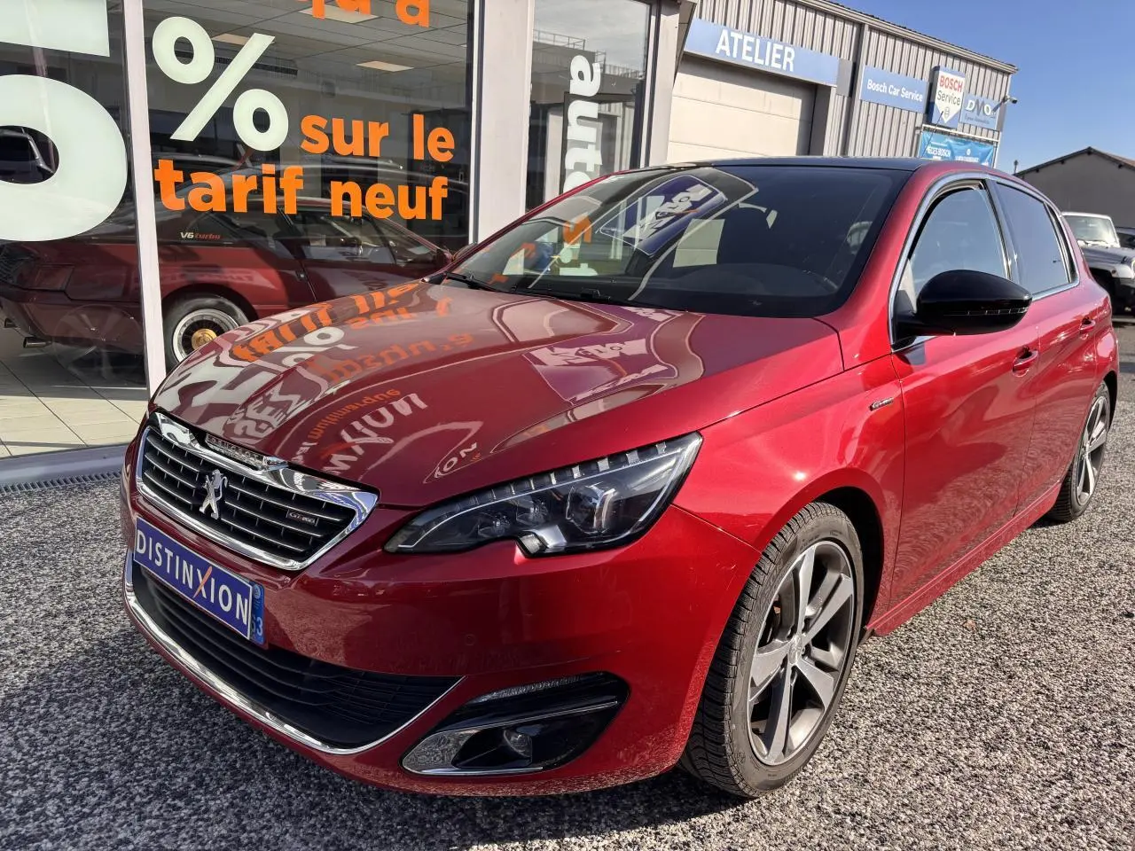 Peugeot 308 GT Line rouge foncé vue 3/4 avant droit avec calandre chromée et jantes aluminium 17 pouces diamantées.