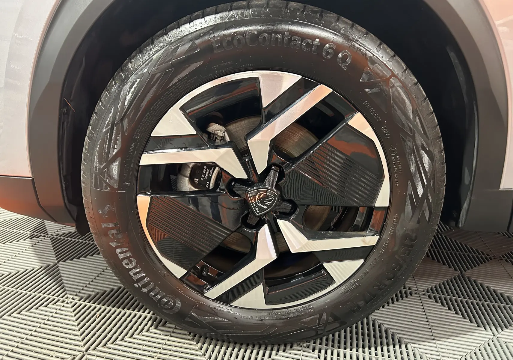 Gros plan sur la roue avant droite du Peugeot 2008 gris 2025 avec jante alliage noire et argentée au design moderne.