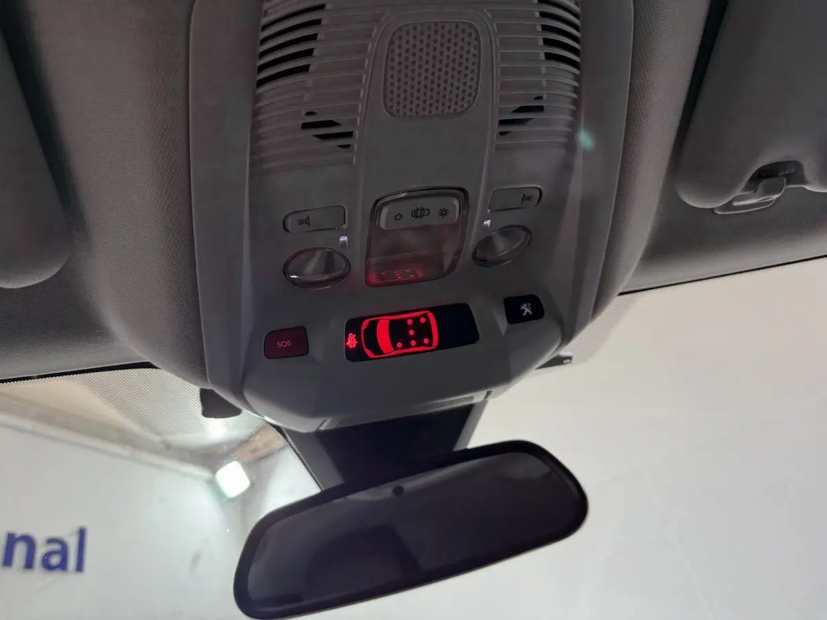 Vue intérieure du plafonnier de la Peugeot 5008 gris clair, avec commandes lumineuses et rétroviseur central visible.
