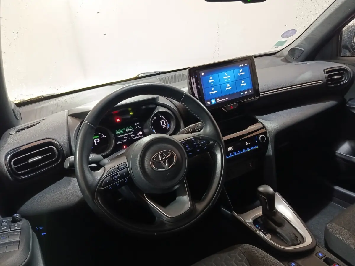Vue intérieure du tableau de bord et volant cuir de la Toyota Yaris Cross 1.5 Hybrid 2022 avec écran tactile central.