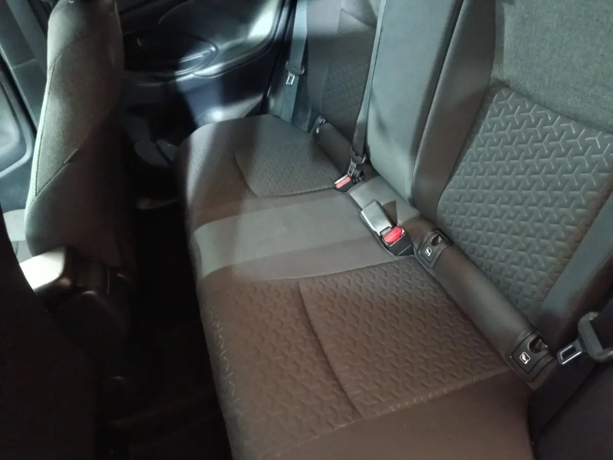 Vue intérieure côté arrière droit montrant la banquette 3 places en tissu gris foncé du Toyota Yaris Cross 2022.