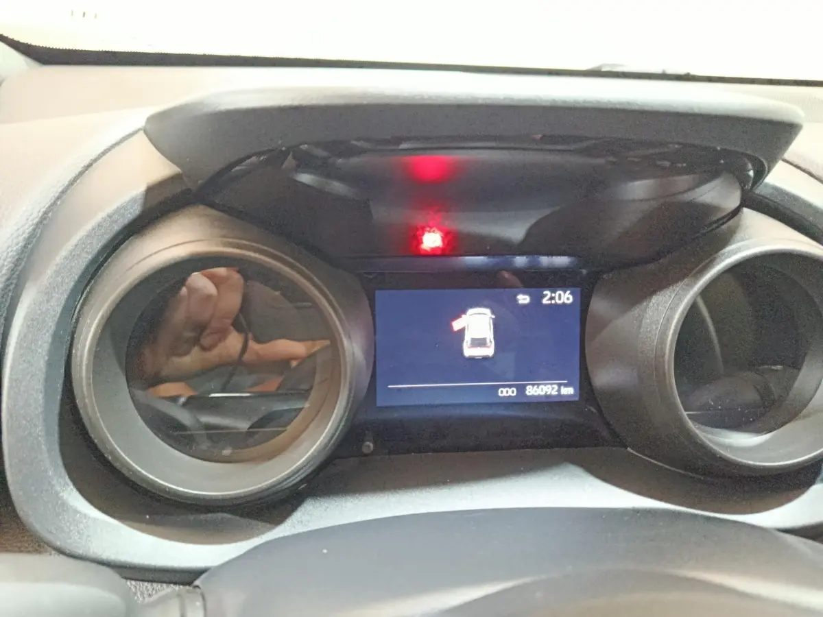 Vue rapprochée du combiné d'instruments numérique de la Toyota Yaris Cross 2022, affichant une alerte porte ouverte.
