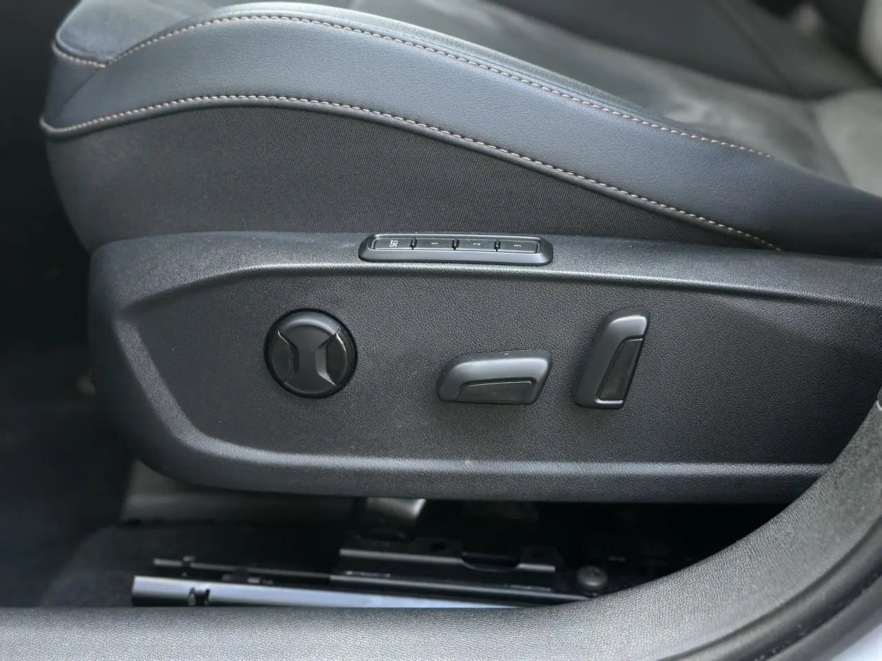 Réglages électriques du siège conducteur en suédine noir asphalte du CUPRA Formentor blanc, vue latérale rapprochée.