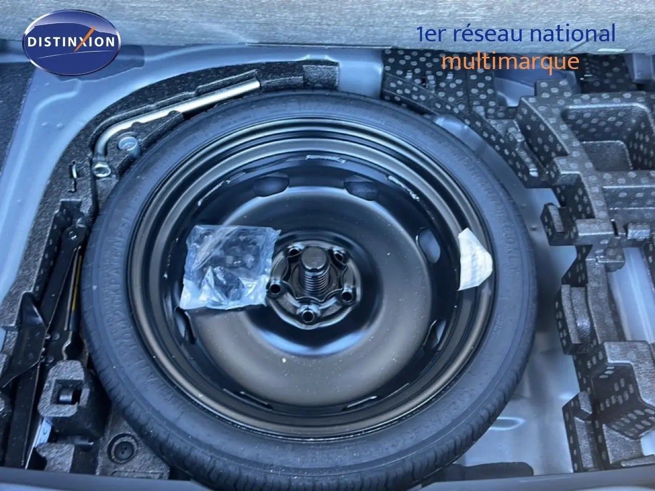 Vue en plongée sur la roue de secours noire et son compartiment dans le coffre d'une CUPRA Formentor 2025.