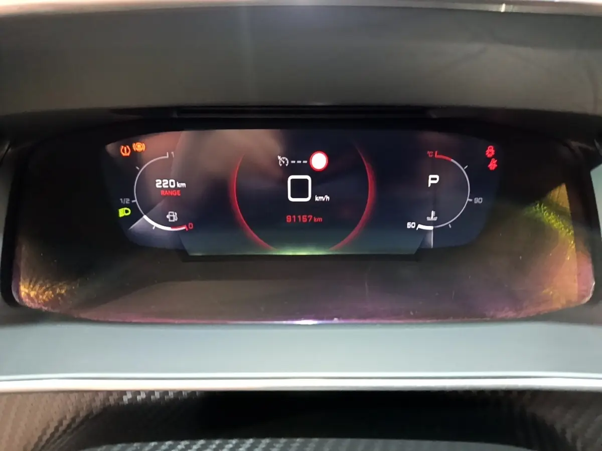 Vue rapprochée du tableau de bord numérique du Peugeot 2008 blanc, affichant la vitesse à 0 km/h et 91 157 km au compteur.