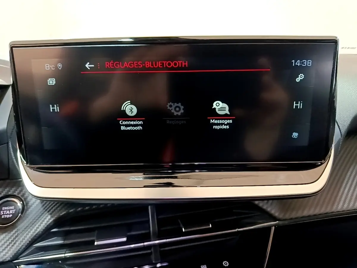 Écran tactile central du Peugeot 2008 blanc, affichant les réglages Bluetooth avec bouton démarrage visible à gauche.