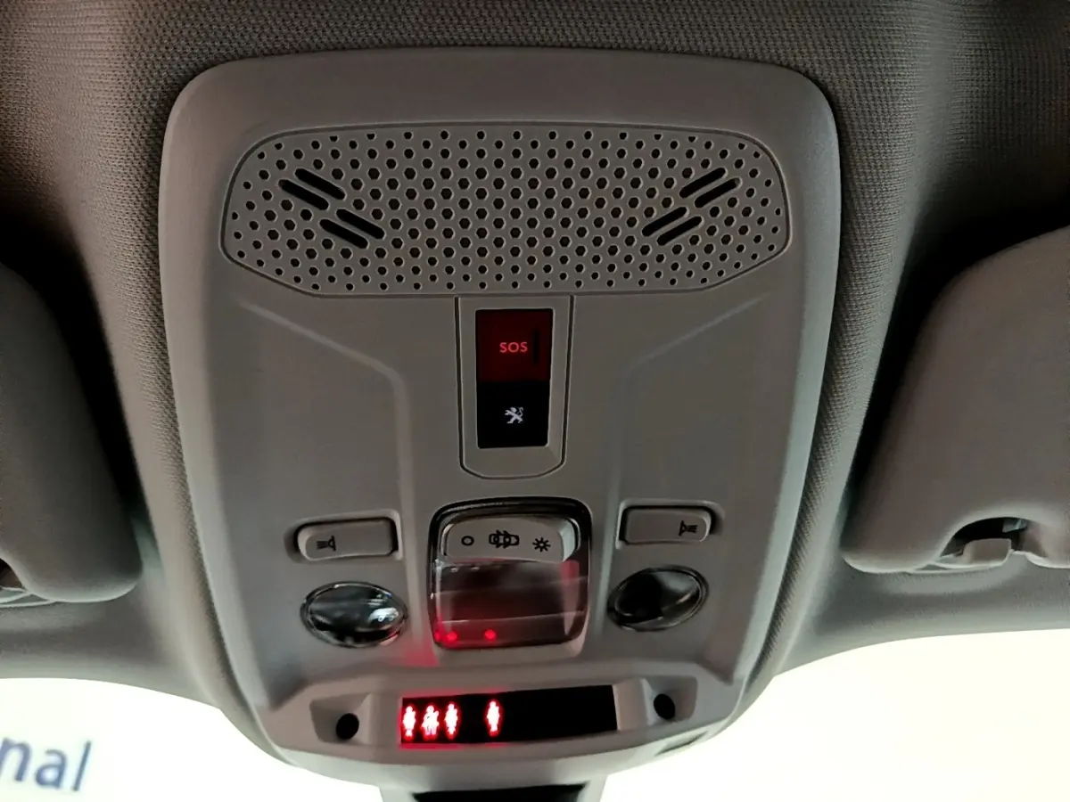 Vue en contre-plongée du plafonnier gris avec bouton SOS et éclairage intérieur rouge du Peugeot 2008 blanc 2021.