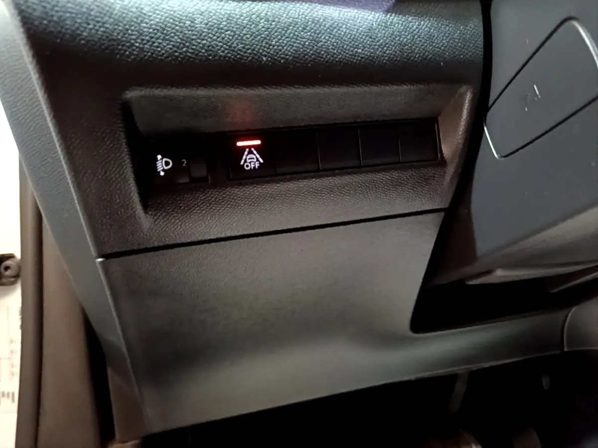 Vue rapprochée du tableau de bord côté gauche du Peugeot 2008 blanc, avec bouton d'assistance au maintien de voie désactivé.