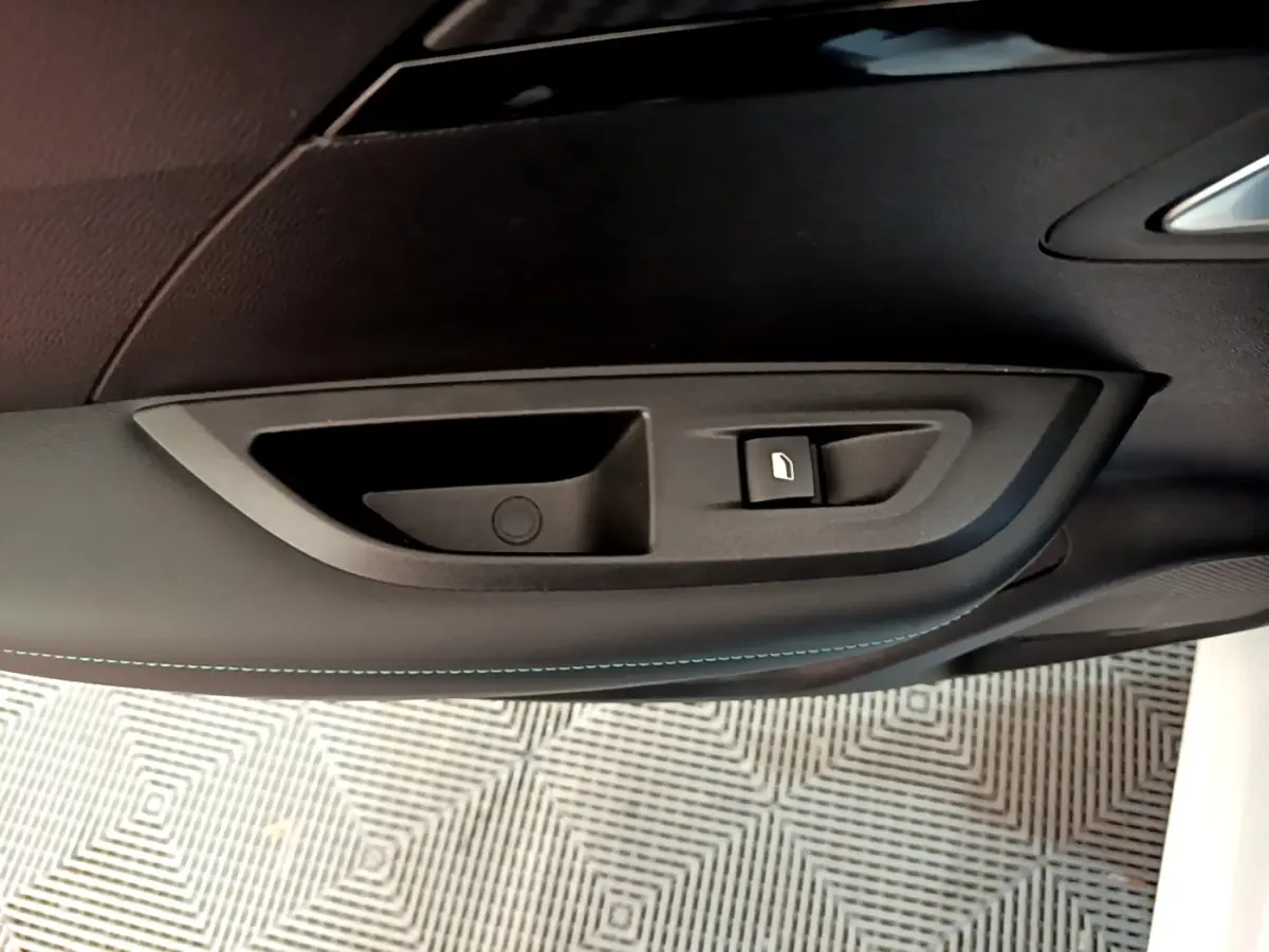 Poignée intérieure de porte côté droit du Peugeot 2008 blanc, avec bouton de verrouillage visible.