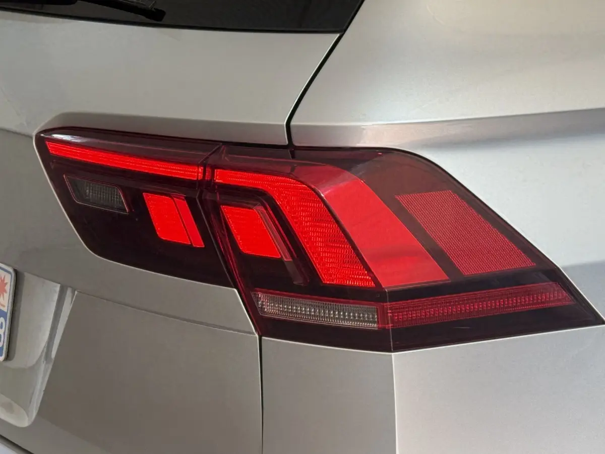 Gros plan sur le feu arrière droit rouge d’un Volkswagen Tiguan gris clair, vue arrière latérale.