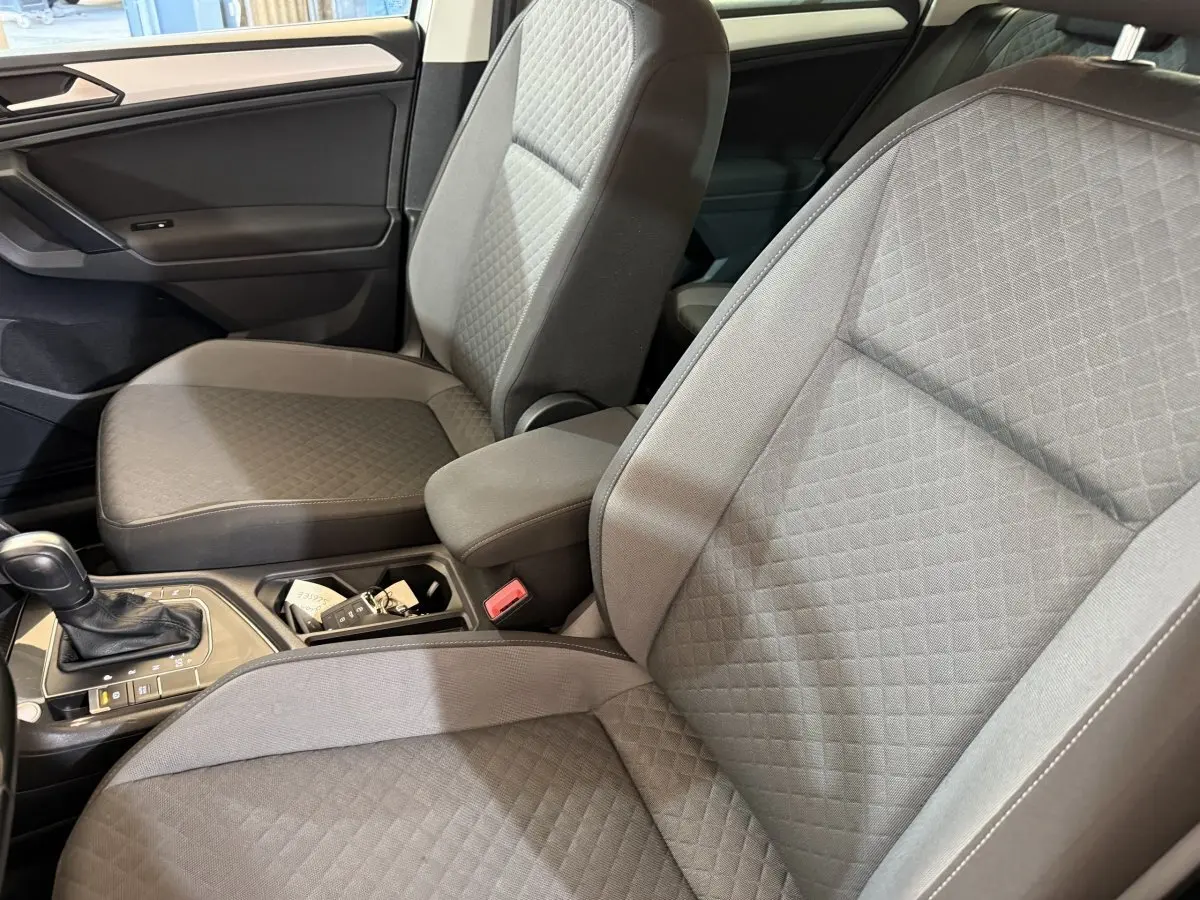 Vue intérieure rapprochée des sièges avant gris clair du Volkswagen Tiguan 2020 avec console centrale et levier de vitesses.