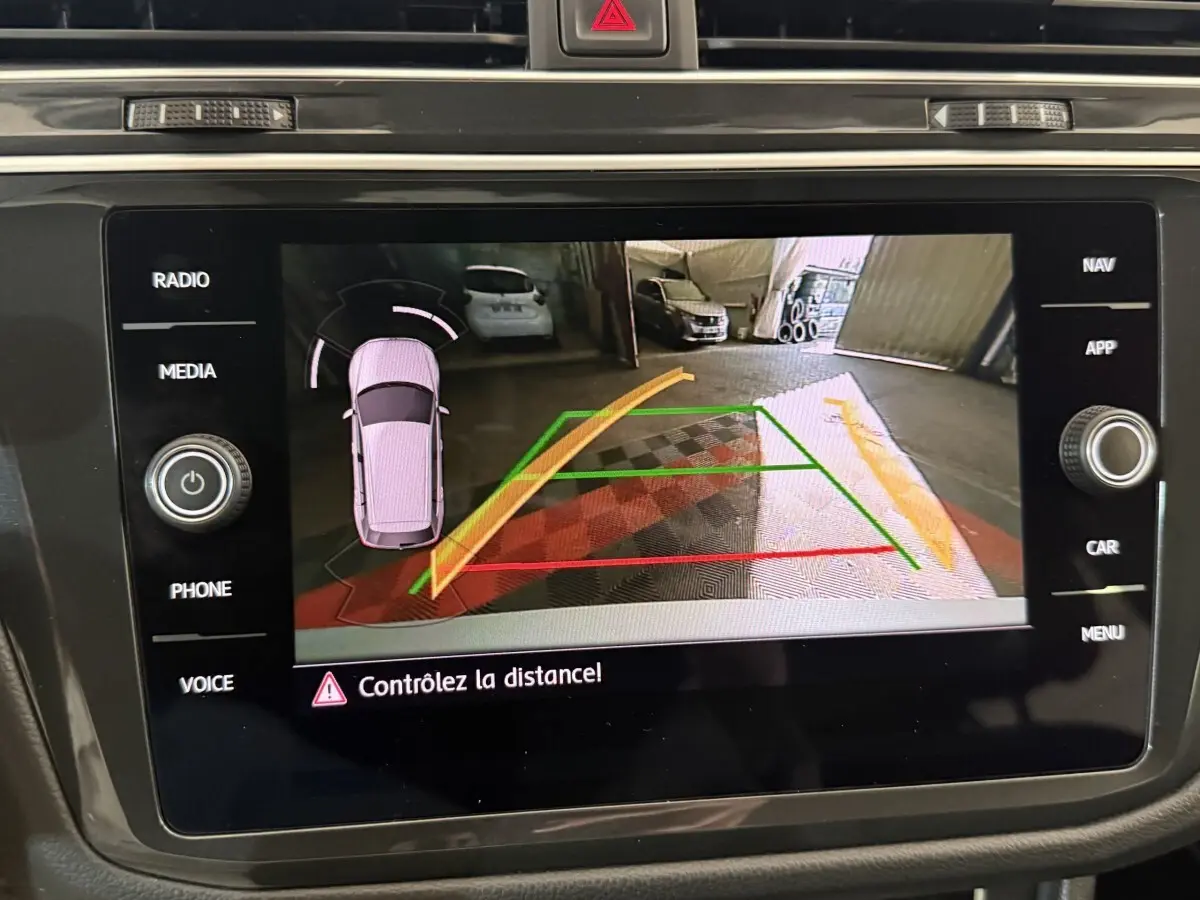 Écran tactile du système de navigation affichant la caméra de recul du Volkswagen Tiguan gris clair, vue arrière.