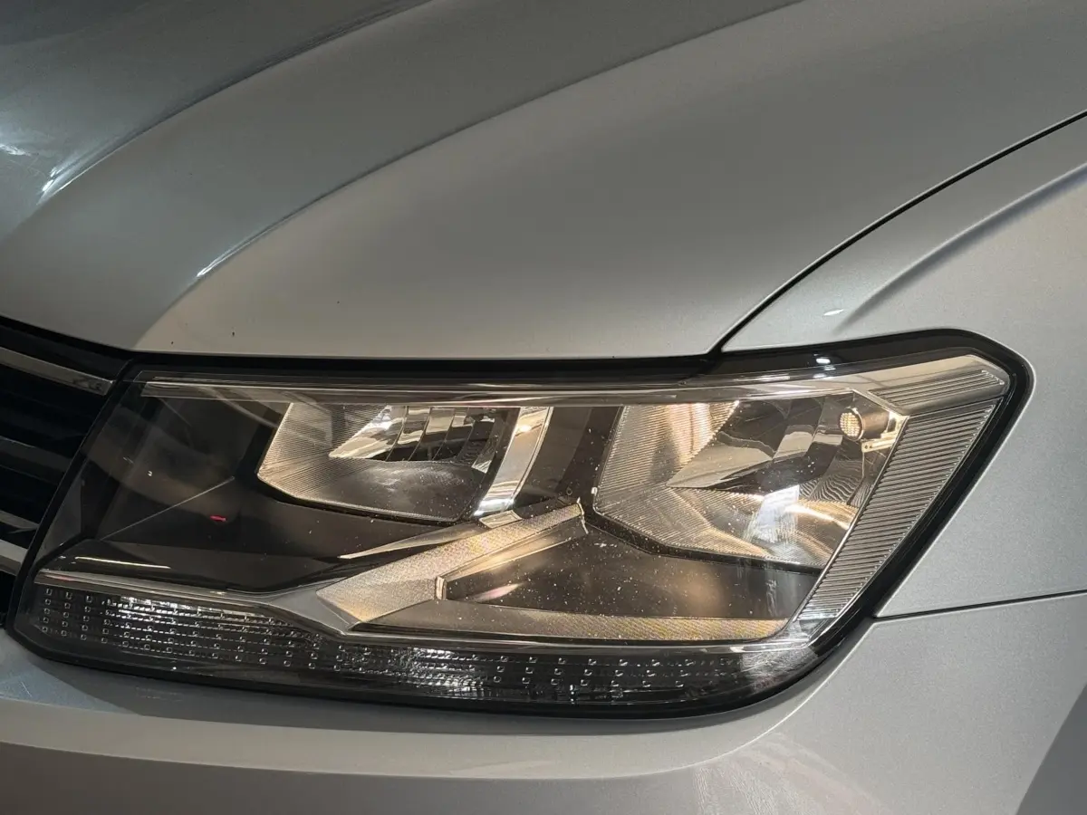 Gros plan sur le phare avant droit gris clair du Volkswagen Tiguan 2020, mettant en valeur ses détails lumineux modernes.