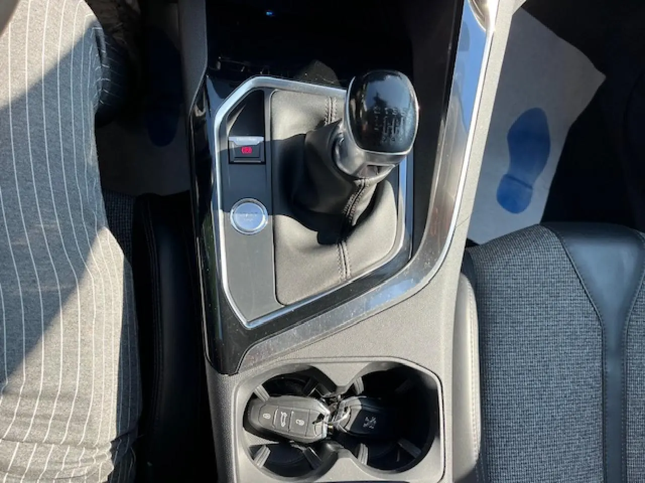 Vue plongeante sur la console centrale du Peugeot 3008 avec levier de vitesse manuel et porte-clés dans un porte-gobelet.