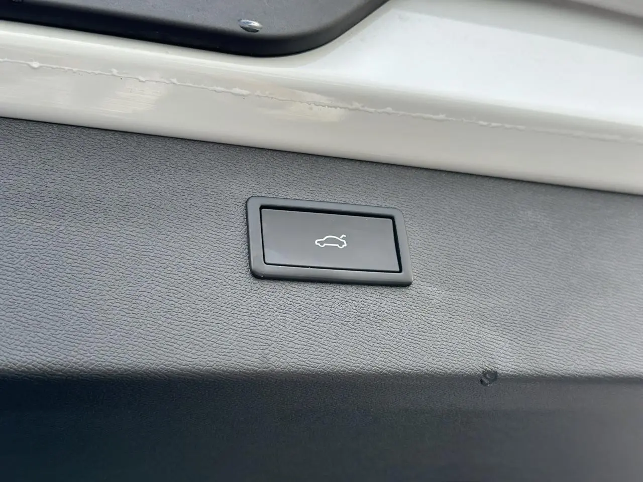 Bouton d'ouverture électrique du hayon sur la garniture intérieure blanche neige du coffre arrière du CUPRA Formentor 2025