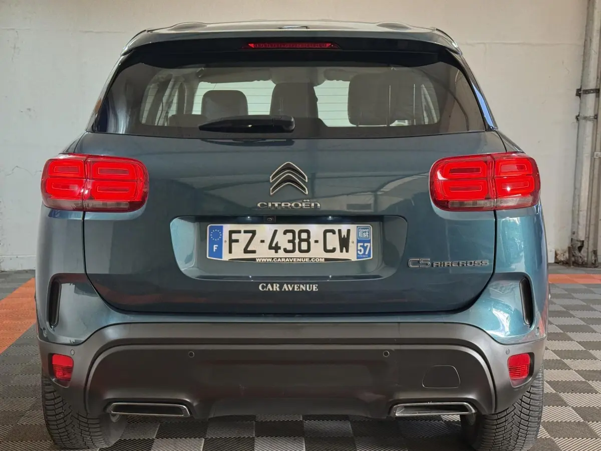 Vue arrière d'un Citroën C5 Aircross bleu avec feux arrière rouges et double sortie d'échappement intégrée.