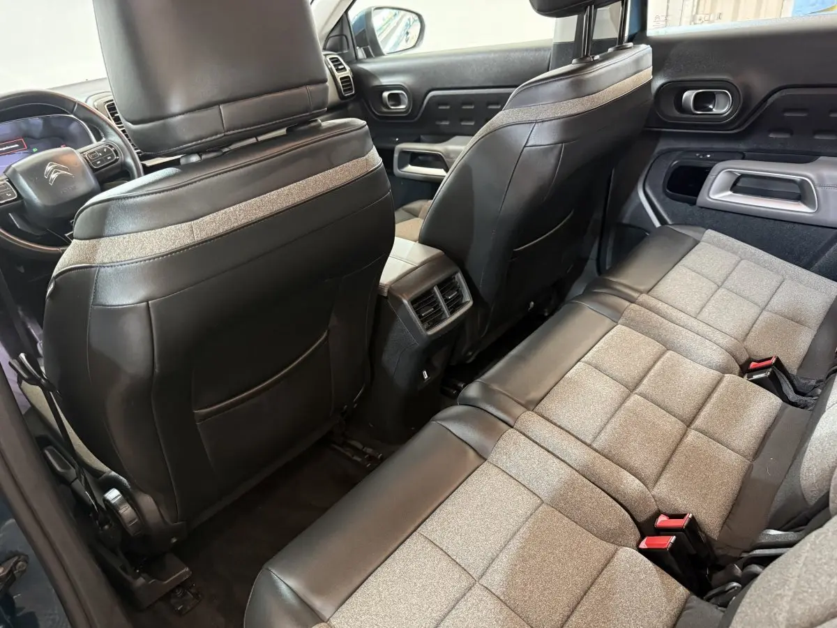 Vue intérieure arrière côté droit du Citroën C5 Aircross 2021 bleu, sièges bicolores tissu et cuir avec console centrale.