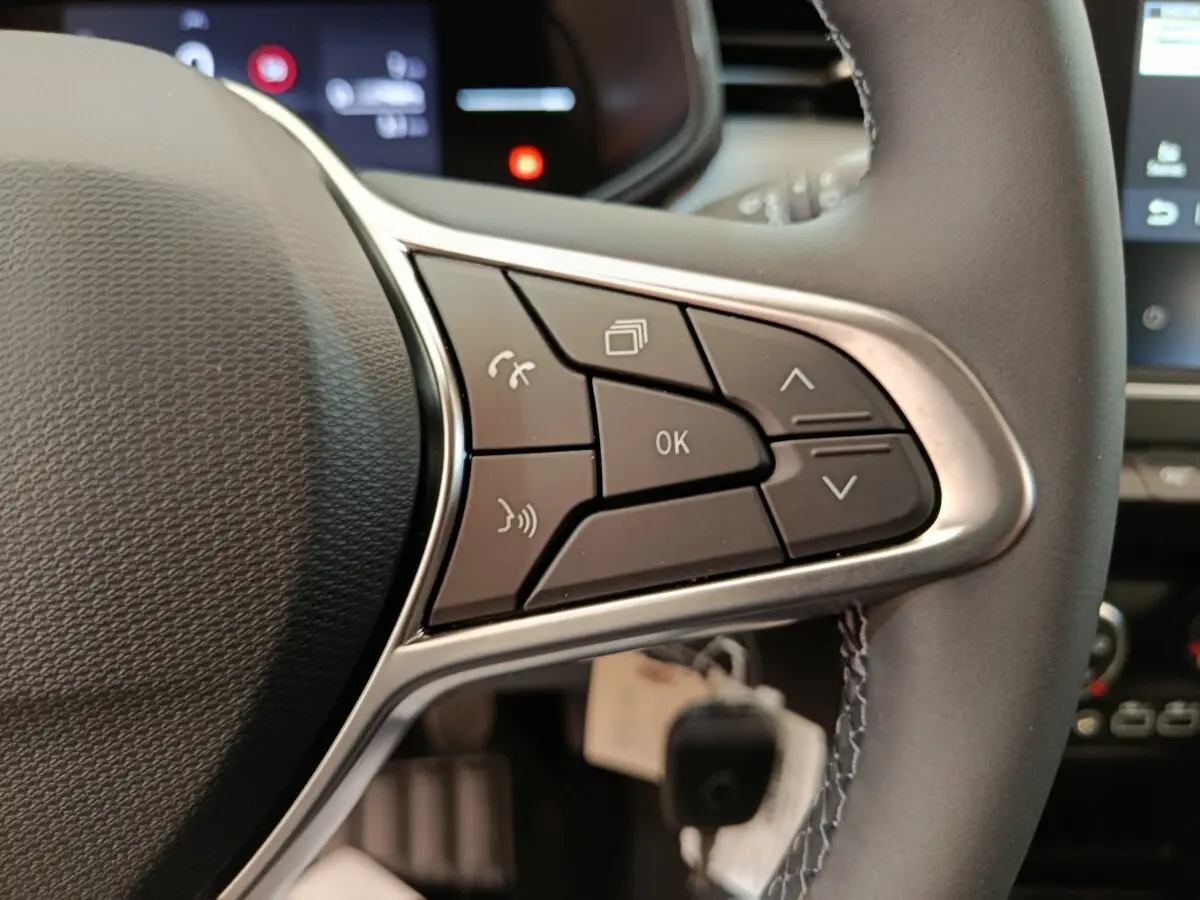 Gros plan sur les commandes multifonctions du volant cuir noir de la Renault Clio 2024, côté gauche.