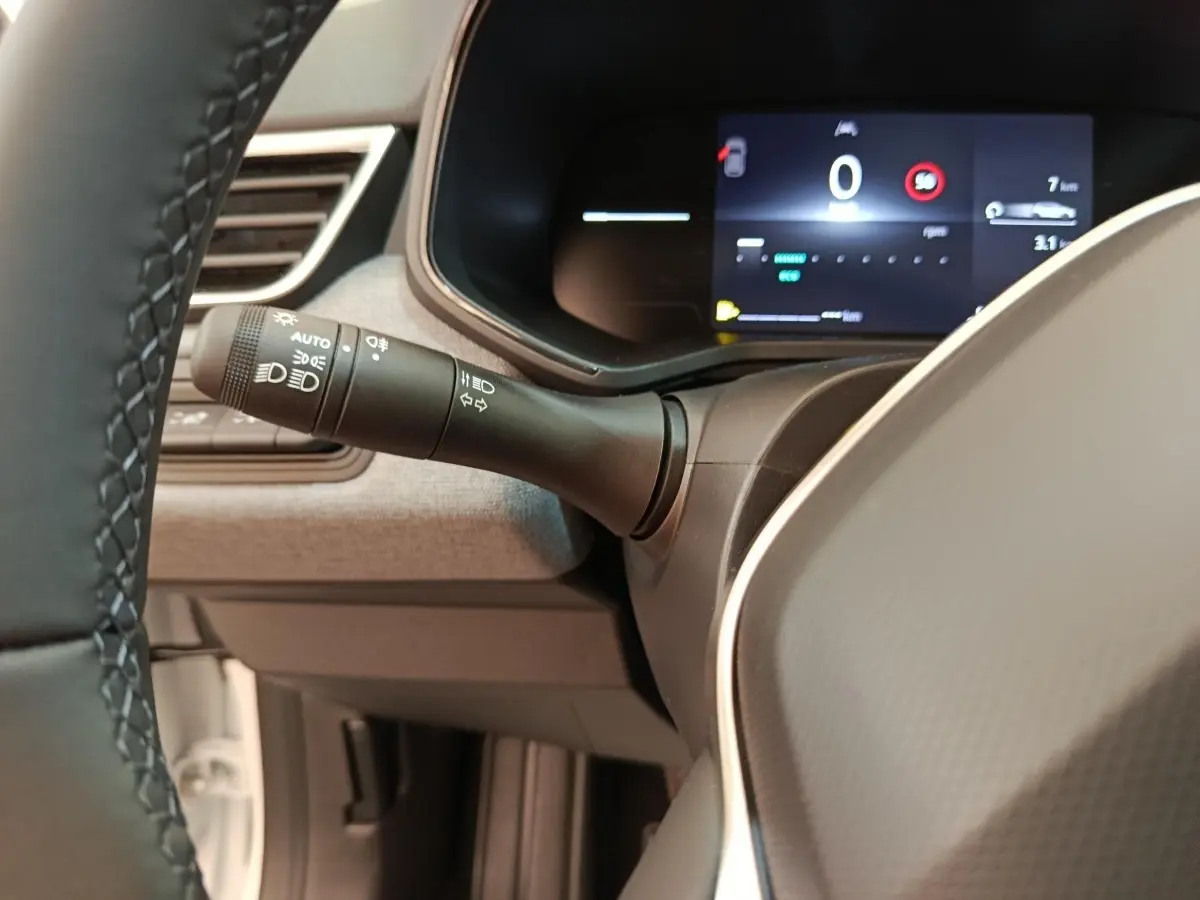 Vue intérieure rapprochée du combiné d’instruments numérique et du commodo d’éclairage de la Renault Clio Evolution TCe 90 2024.