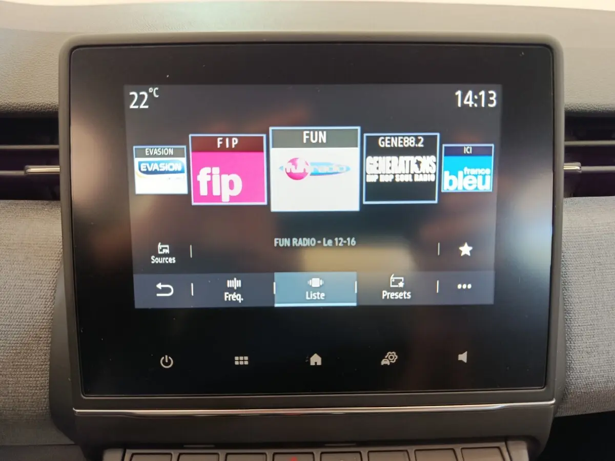 Écran tactile central 7 pouces de la Renault Clio blanche 2024 affichant les stations radio en intérieur.