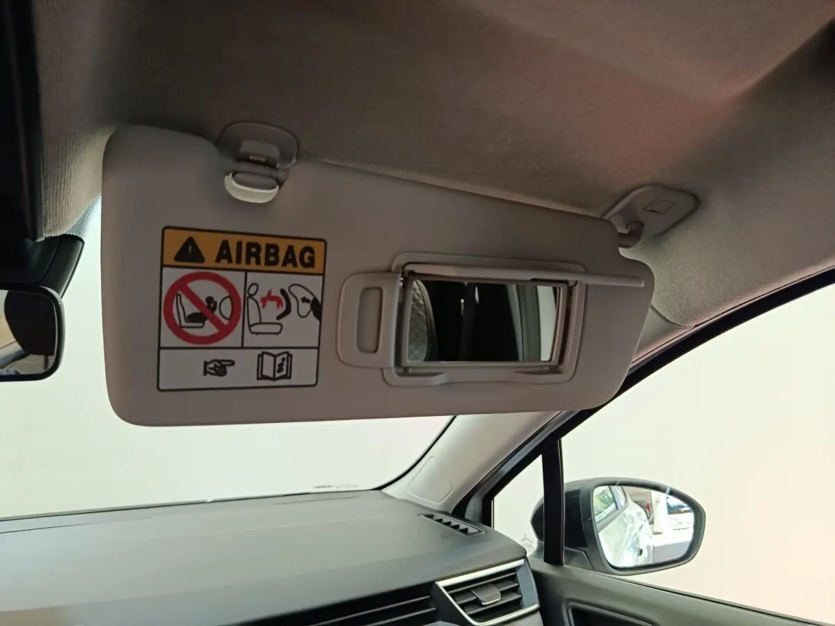 Vue intérieure côté passager du pare-soleil avec miroir et avertissement airbag dans une Renault Clio blanche 2024.