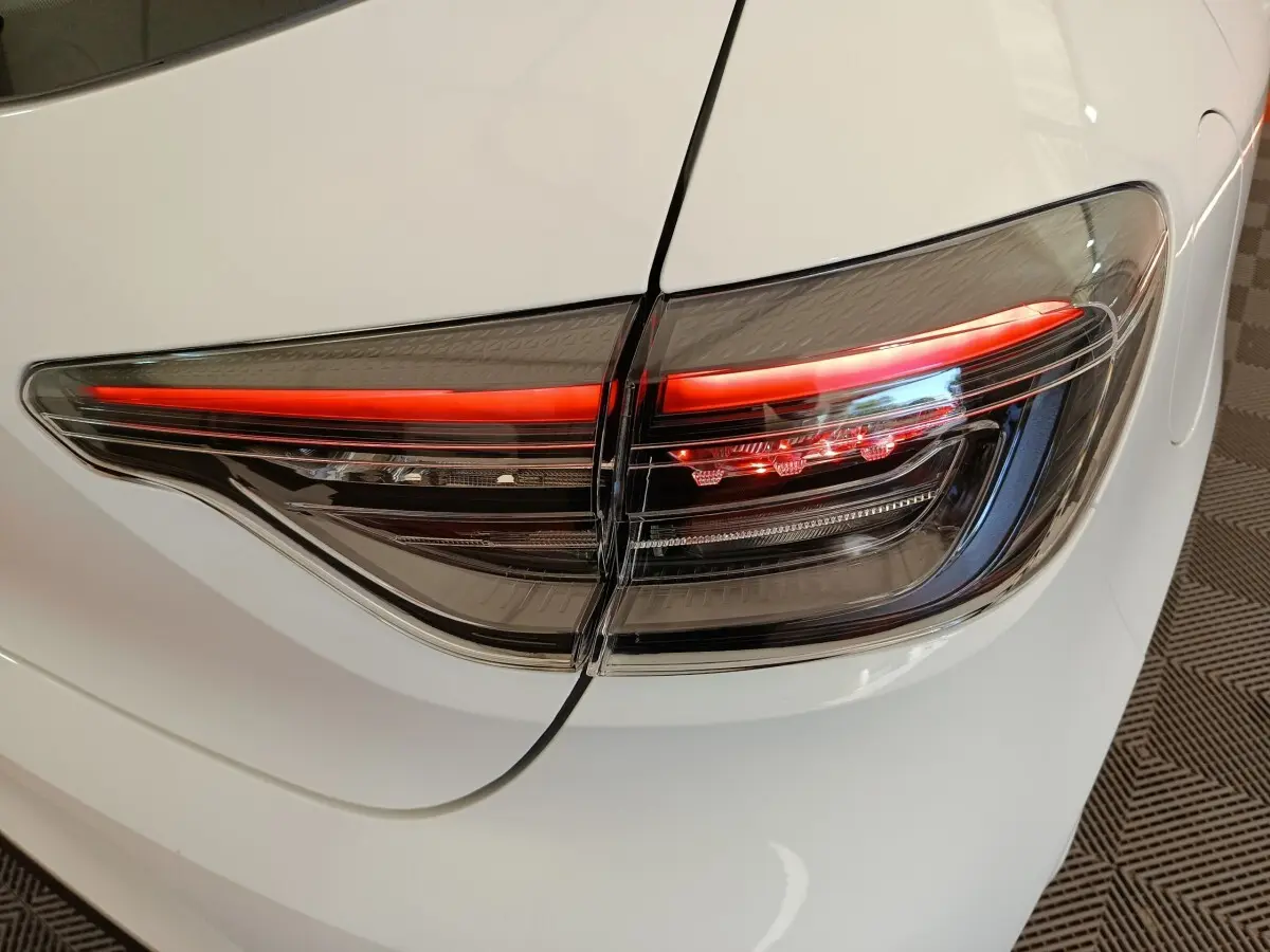 Gros plan sur le feu arrière droit rouge et noir d’une Renault Clio blanche 2024, vue arrière côté droit.