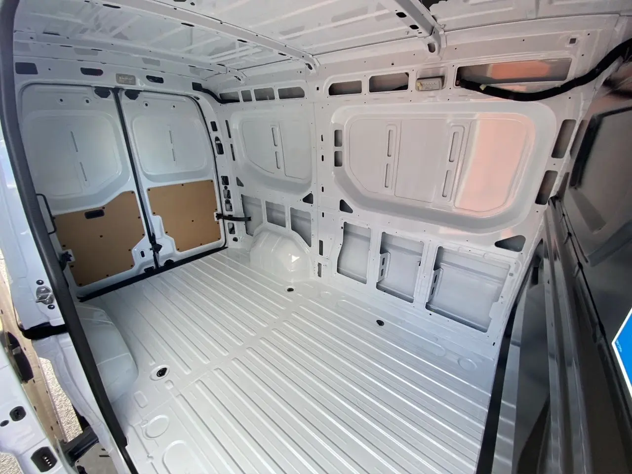 Vue intérieure arrière du Renault Master blanc 2025, montrant l'espace de chargement tôlé et le plafond avec éclairage halogène.