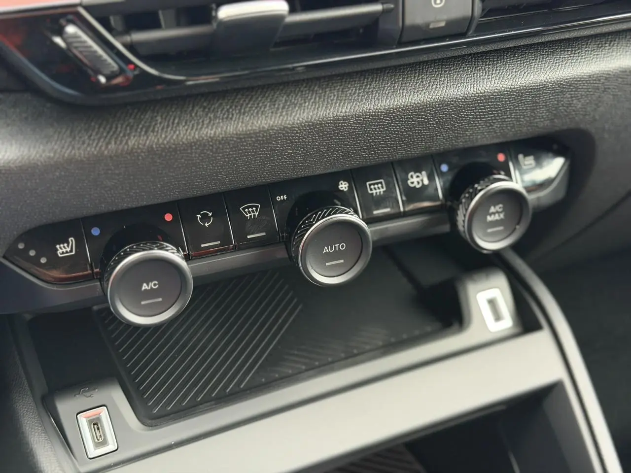 Gros plan sur la console centrale de la Citroën C4 2025, boutons de climatisation et USB visibles.