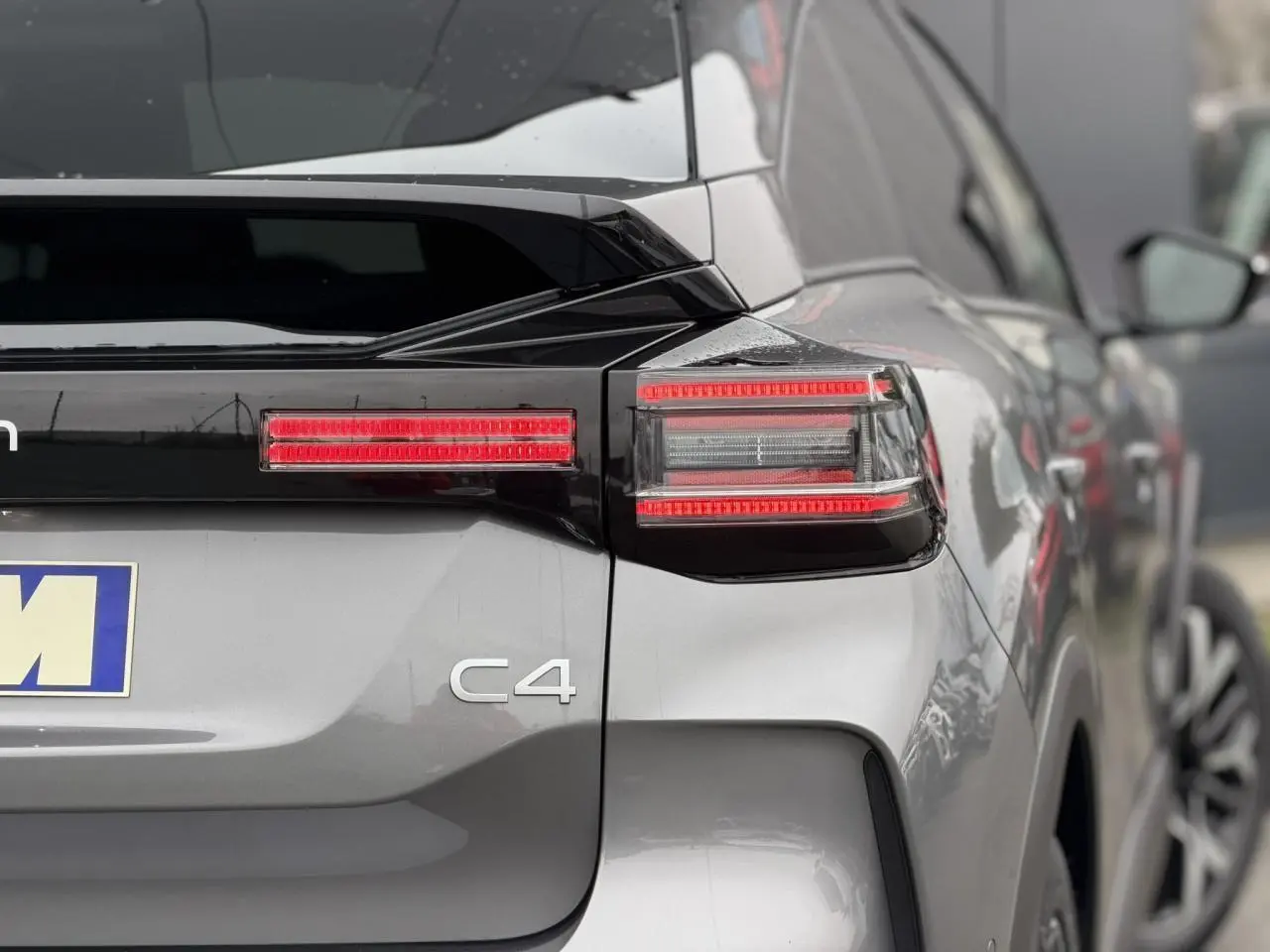 Vue arrière droite d'une Citroën C4 gris Mercury avec toit noir et feux arrière LED distinctifs.