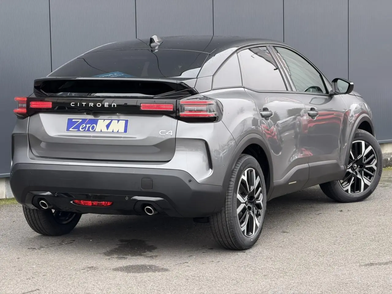 Vue 3/4 arrière droite d'une Citroën C4 gris Mercury avec toit noir Perla Nera et jantes alliage 18 pouces.