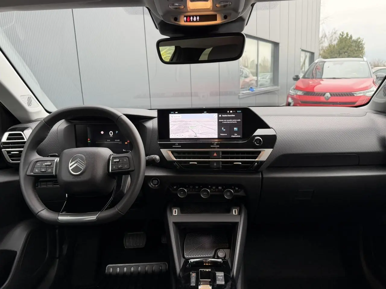 Vue intérieure avant du tableau de bord du Citroën C4 gris Mercury, avec écran tactile central et volant cuir noir.