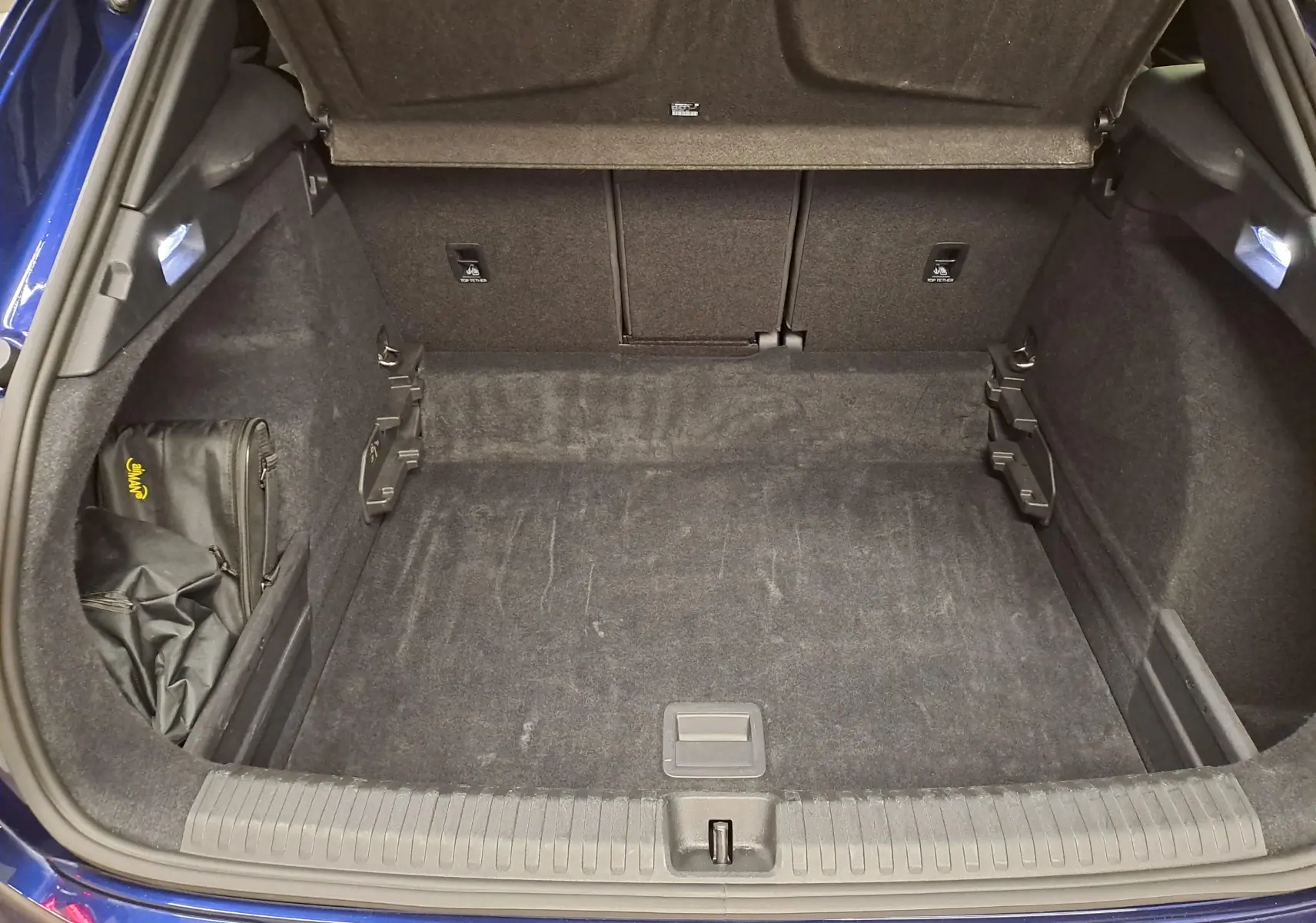 Coffre ouvert vu de l'arrière d'une CUPRA TERRAMAR Bleu Cosmos, montrant un espace de chargement propre et bien fini.