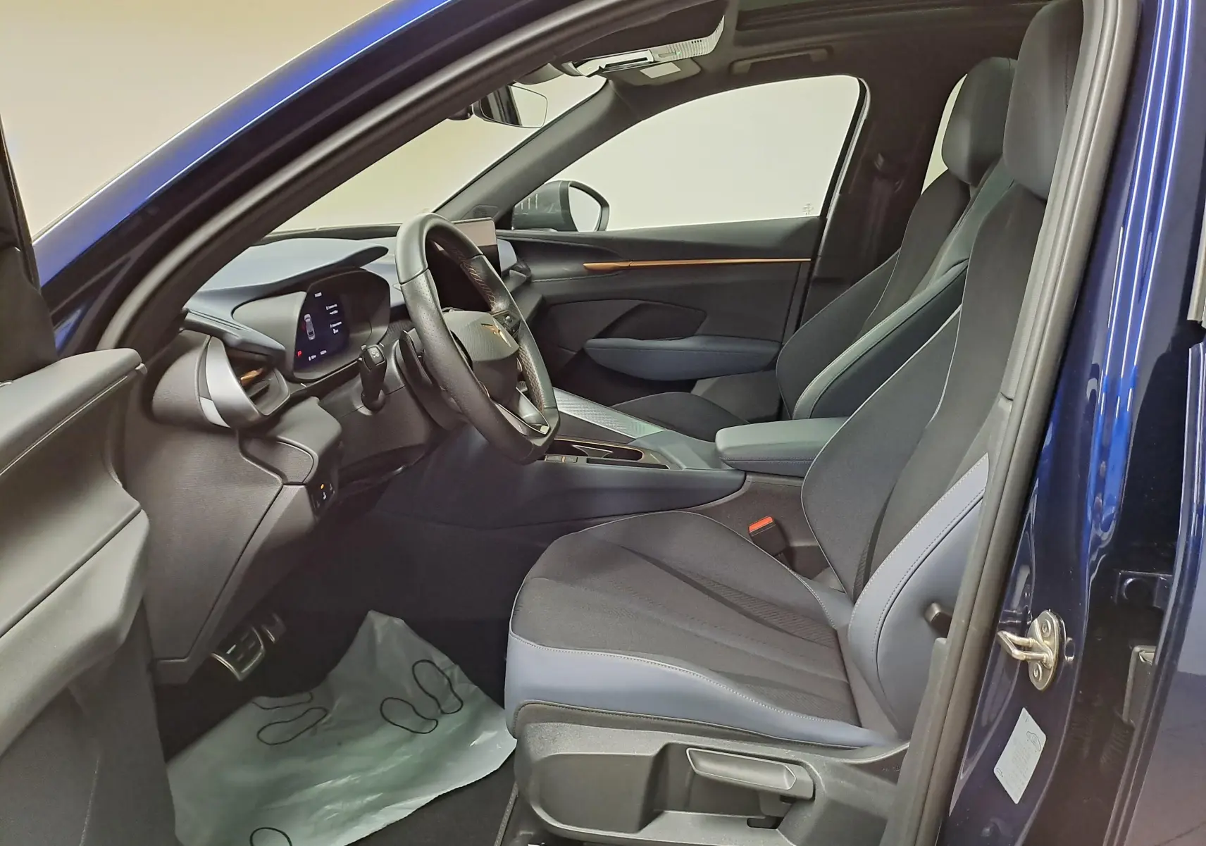 Vue intérieure côté conducteur de la CUPRA TERRAMAR 2025 en Bleu Cosmos, avec sièges sport et tableau de bord numérique.