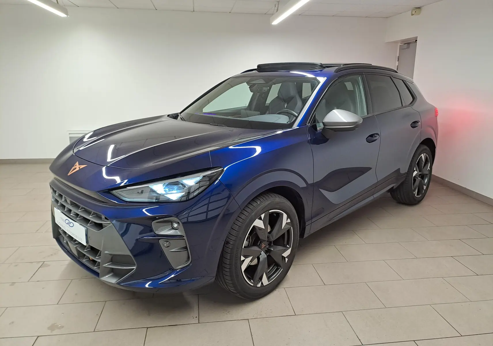 Vue 3/4 avant d'une CUPRA TERRAMAR 2025 bleu cosmos avec jantes 19'' usinées et toit ouvrant panoramique ouvert.