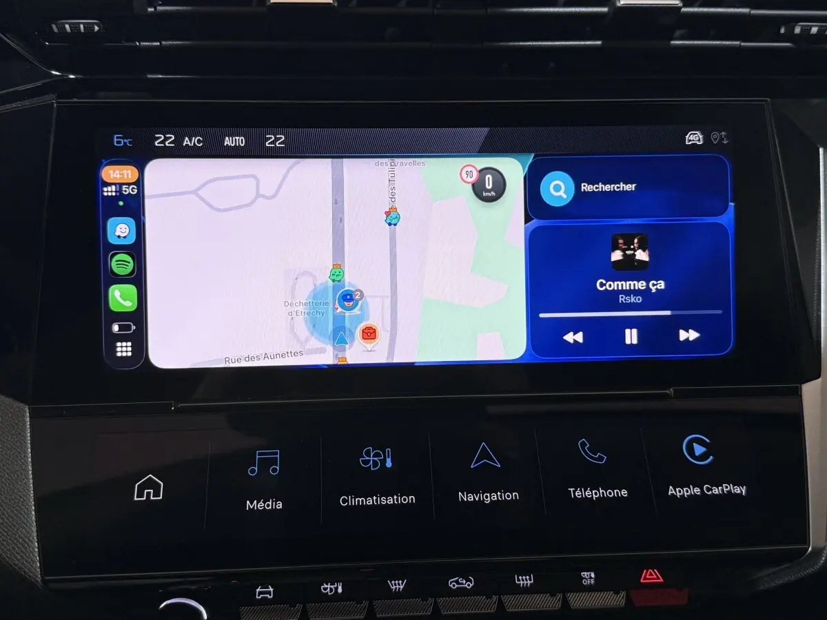 Écran tactile central de la Peugeot 308 rouge, affichant navigation et interface Apple CarPlay, vue intérieure frontale.