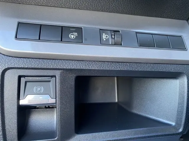 Gros plan sur les commandes de lève-vitre et frein à main électronique du Peugeot Expert Cabine Approfondie gris acier.