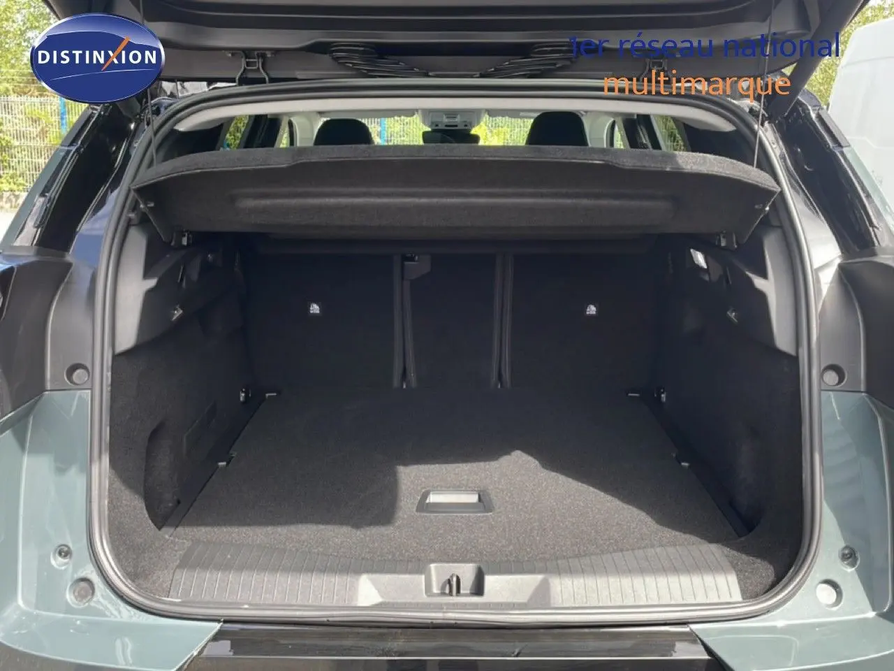 Coffre ouvert vu de l'arrière d'un Citroën C5 Aircross Hybrid vert Astoria Metal, espace de chargement vide et propre.