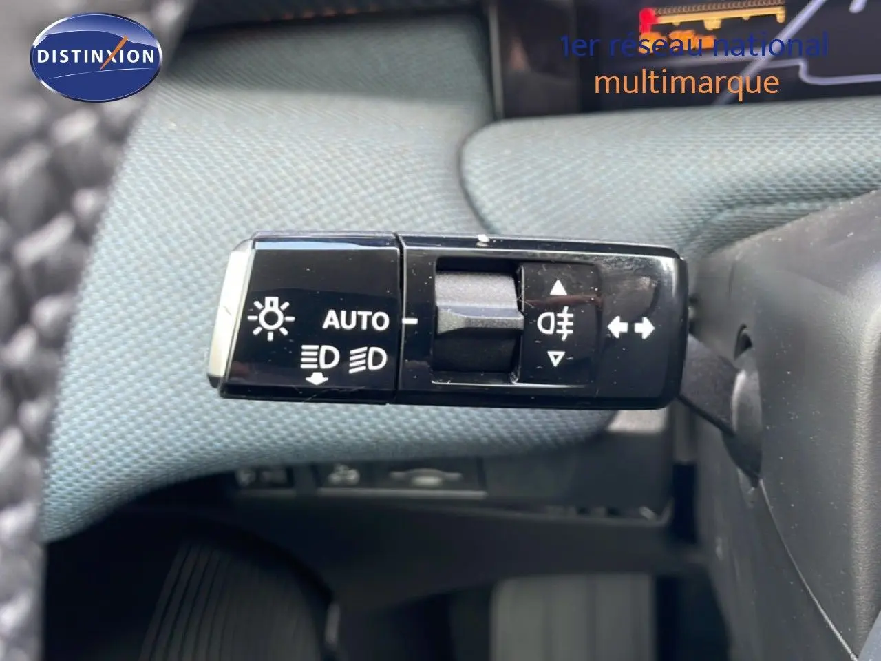 Gros plan sur la commande des feux et clignotants du Citroën C5 Aircross Hybrid, intérieur tissu gris.