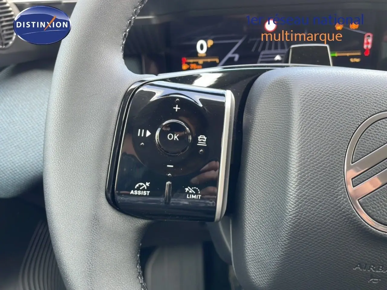 Gros plan sur les commandes au volant du Citroën C5 Aircross Hybrid, volant en cuir noir avec logo central visible.