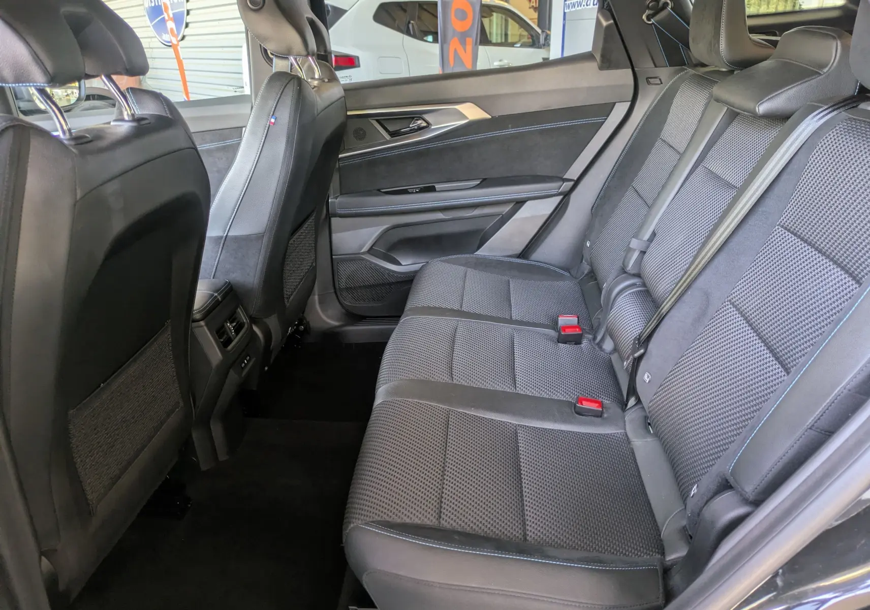 Vue intérieure côté droit des sièges arrière en tissu mixte noir avec surpiqûres bleues du Renault Espace VI E-Tech Full Hybrid 2025.