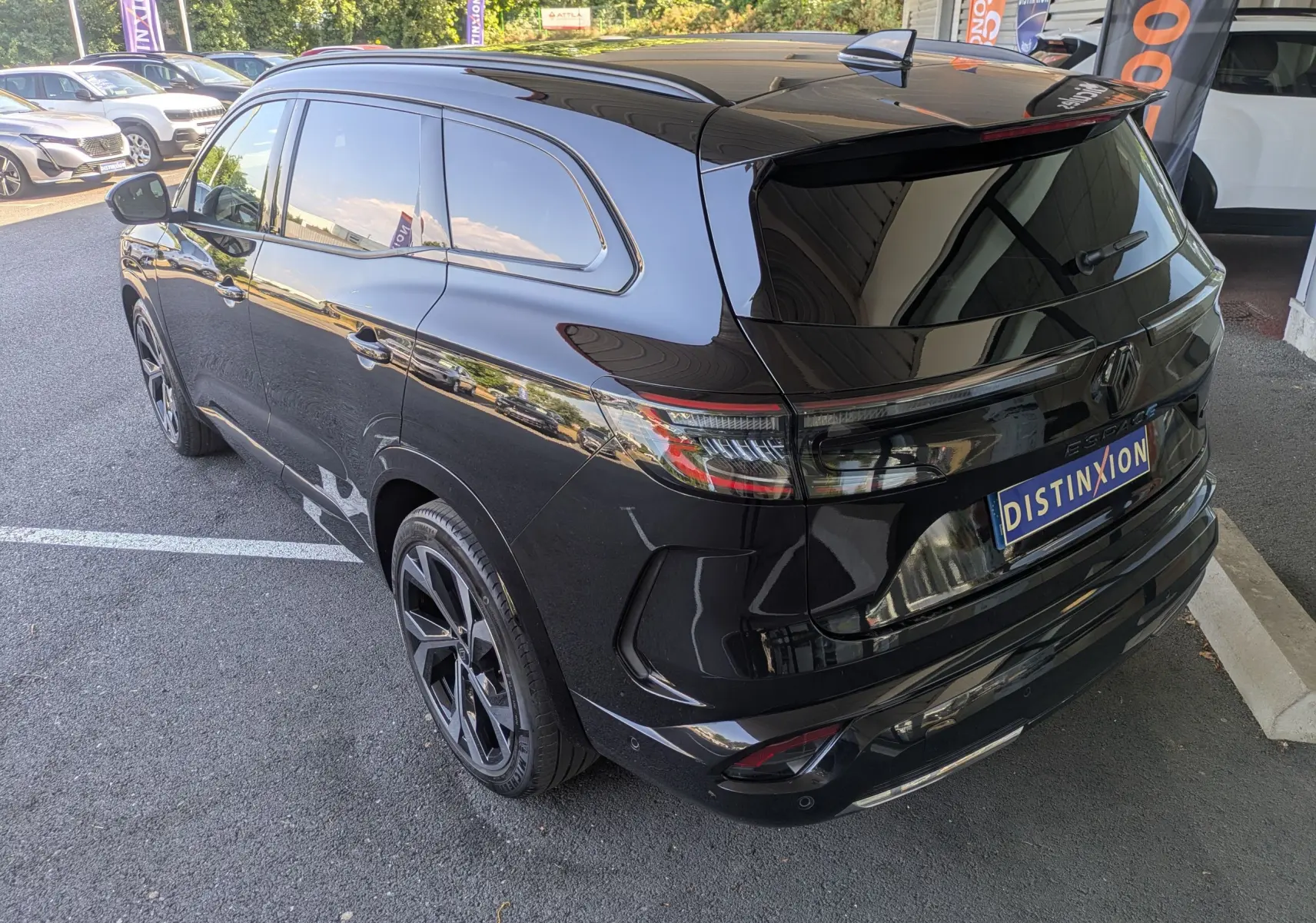 Vue 3/4 arrière droite du Renault Espace VI E-Tech Full Hybrid noir étoile, avec jantes alliage 20 pouces Daytona et barres de toit.