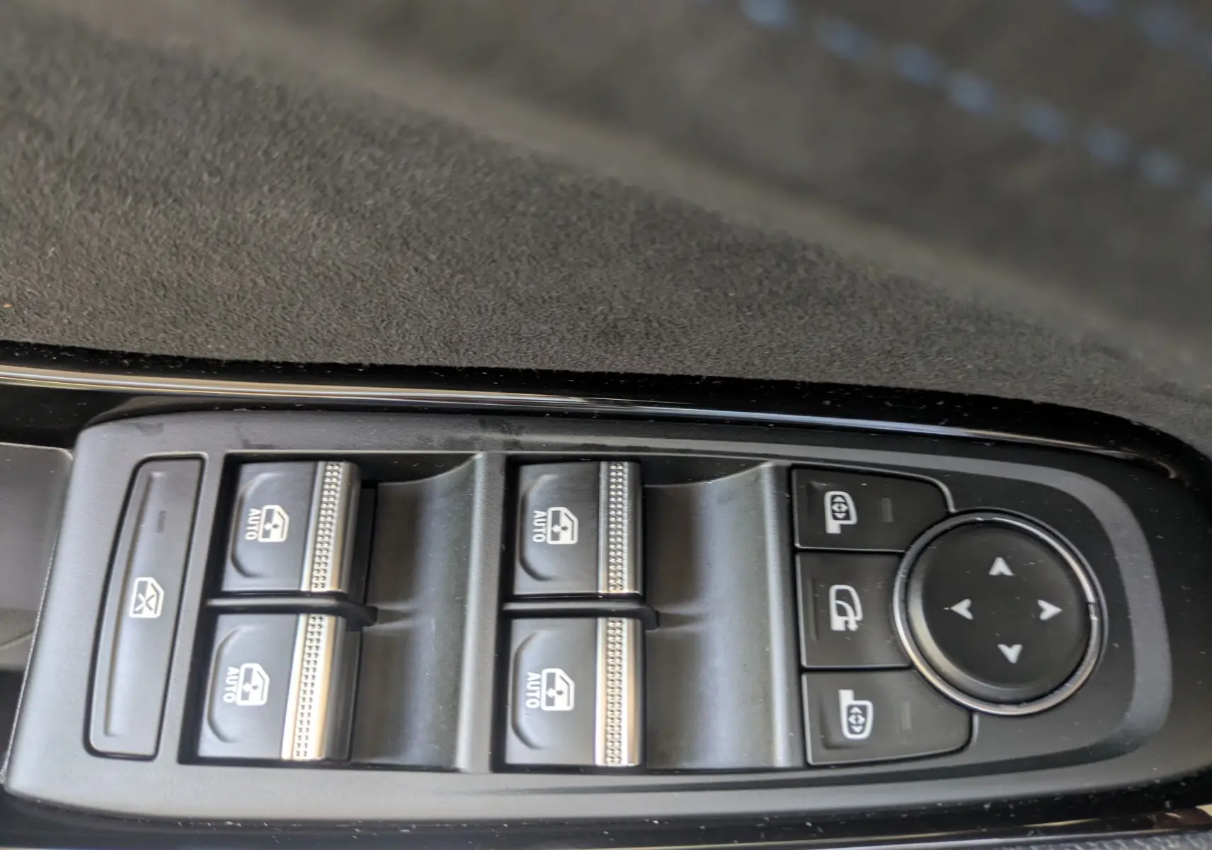 Gros plan sur les commandes de lève-vitres et rétroviseurs du côté gauche intérieur du Renault Espace VI noir étoile.