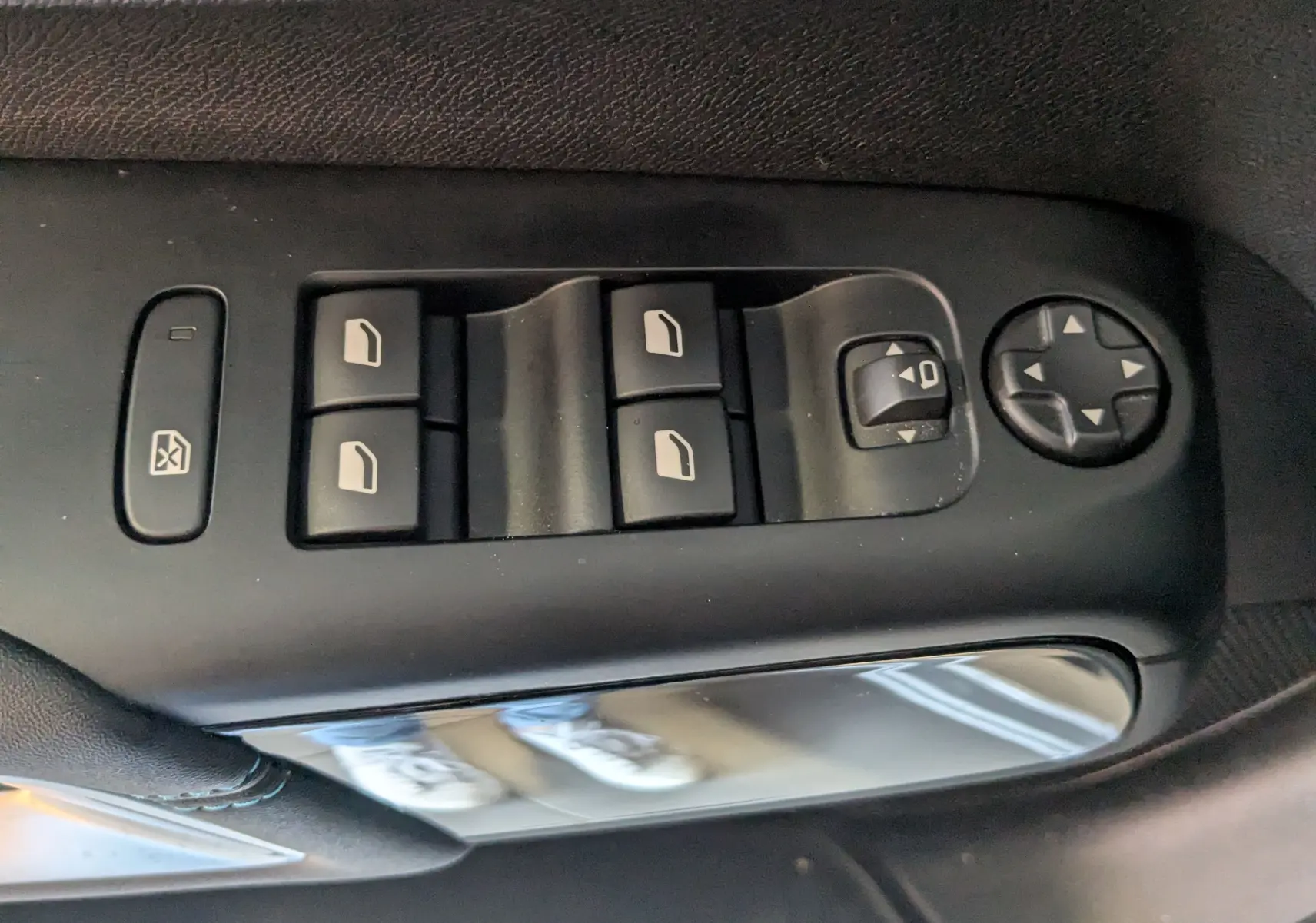 Gros plan sur les commandes de lève-vitres et réglage des rétroviseurs côté conducteur d’un Citroën C5 Aircross gris Artens.