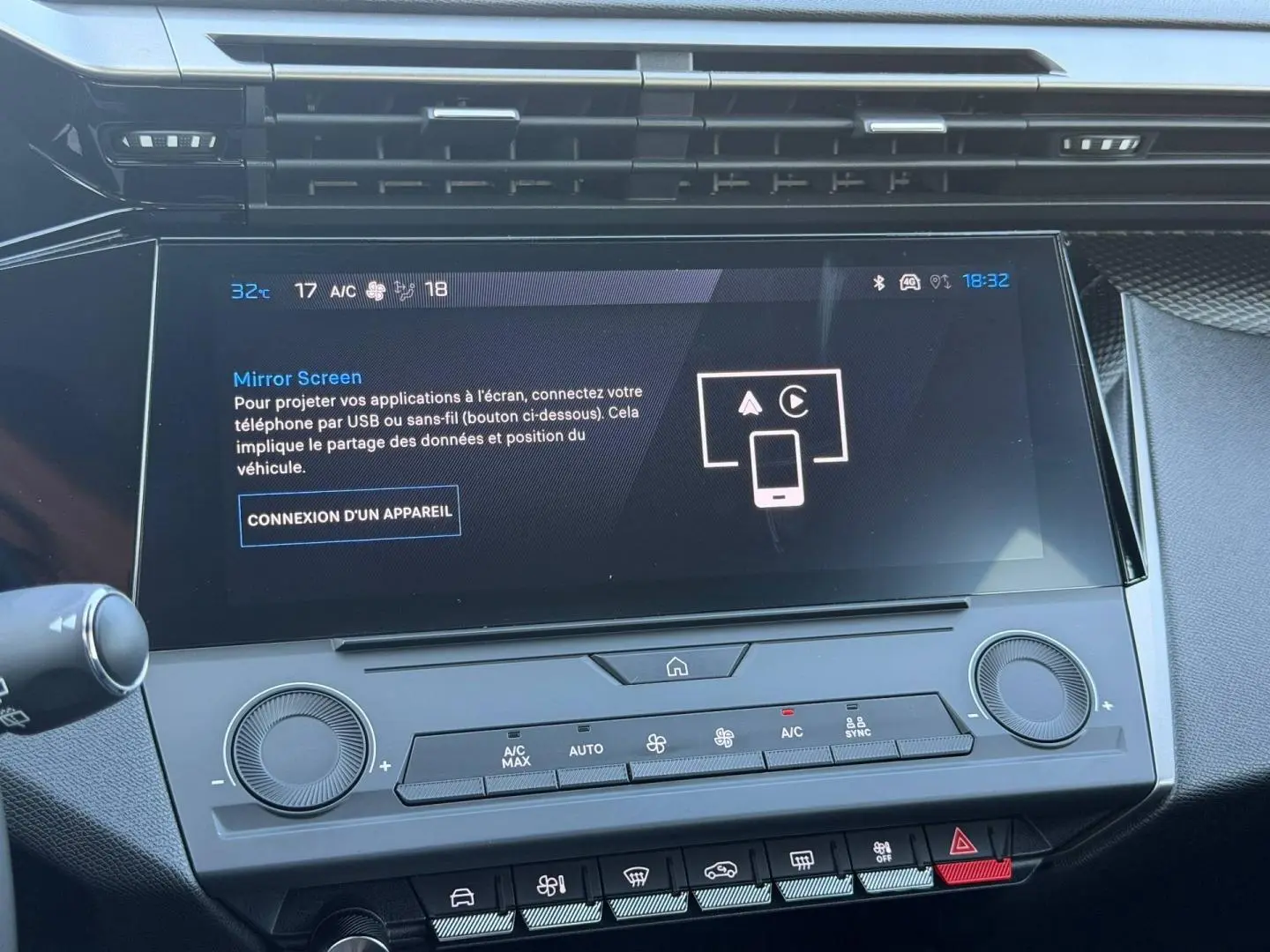 Écran tactile central et commandes climatisation de la Peugeot e-308 noire, vue intérieure frontale rapprochée.