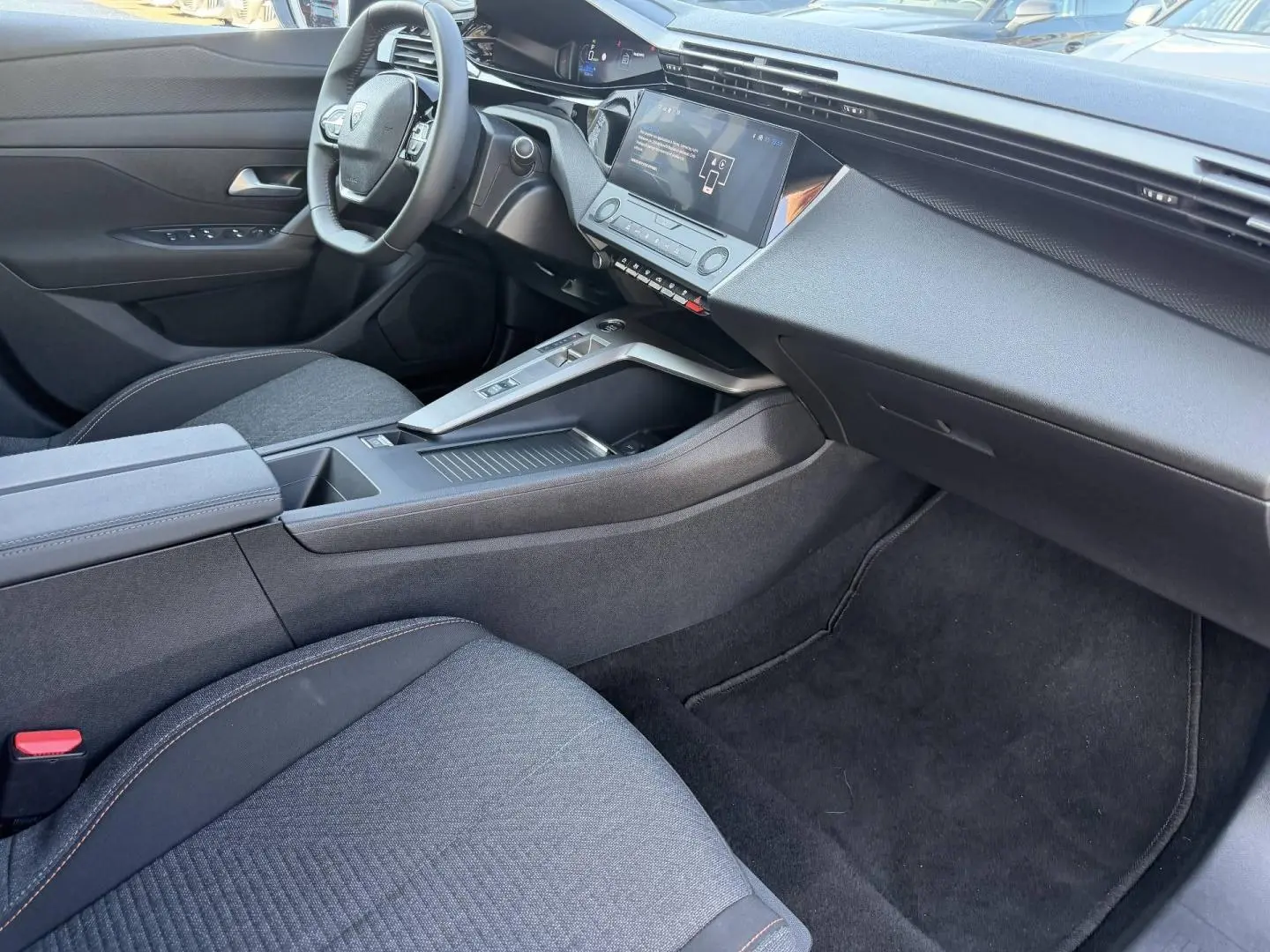 Intérieur avant droit de la Peugeot e-308 2025 noir Perla Nera, avec tableau de bord moderne et écran tactile central.