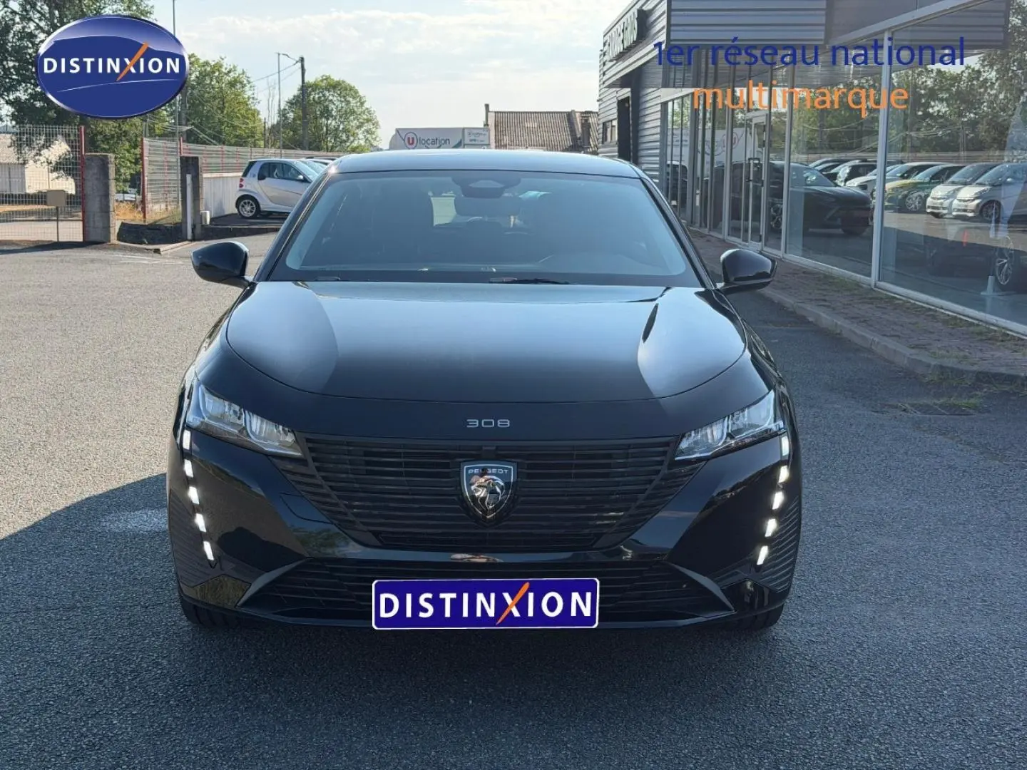 Vue avant d'une Peugeot 308 e-308 noire Perla Nera avec feux LED diurnes verticaux allumés.
